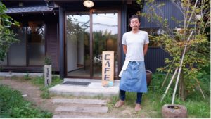 工藤統さんと、経営するカフェ「KOZUKA513」のエントランス。大山千枚田へ車で5分少々の場所にある。