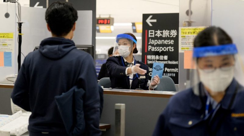 An officer wearing a face mask and shield gestures to a passenger arriving from Hong Kong, at a quarantine station at Narita airport, Chiba prefecture on March 9, 2020. - Japanese Prime Minister Shinzo Abe on March 5 announced that foreign arrivals who have recently been in China or South Korea would be required to spend 14 days in quarantine amid concerns of the COVID-19 novel coronavirus. (Photo by Kazuhiro NOGI / AFP)