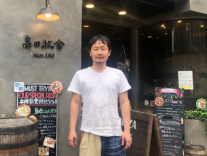 「Pizzeria TAKATA BOKUSYA」の前で、４代目店主・藤田智紀さん
