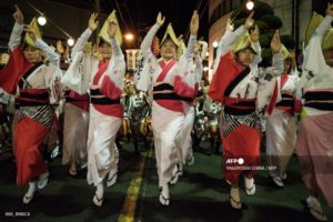 This photo taken on August 16, 2017 shows dancers performing on a street at the Ikeda Awa Odori Festival in the city of Miyoshi, about 80 kms west of Tokushima, Tokushima prefecture, on Japan's Shikoku island. - Various places in Tokushima prefecture hold the annual Awa Odori festival during "obon", an annual Buddhist period in August to welcome ancestors souls which are believed to return to this world and visit their families. (Photo by YASUYOSHI CHIBA / AFP)